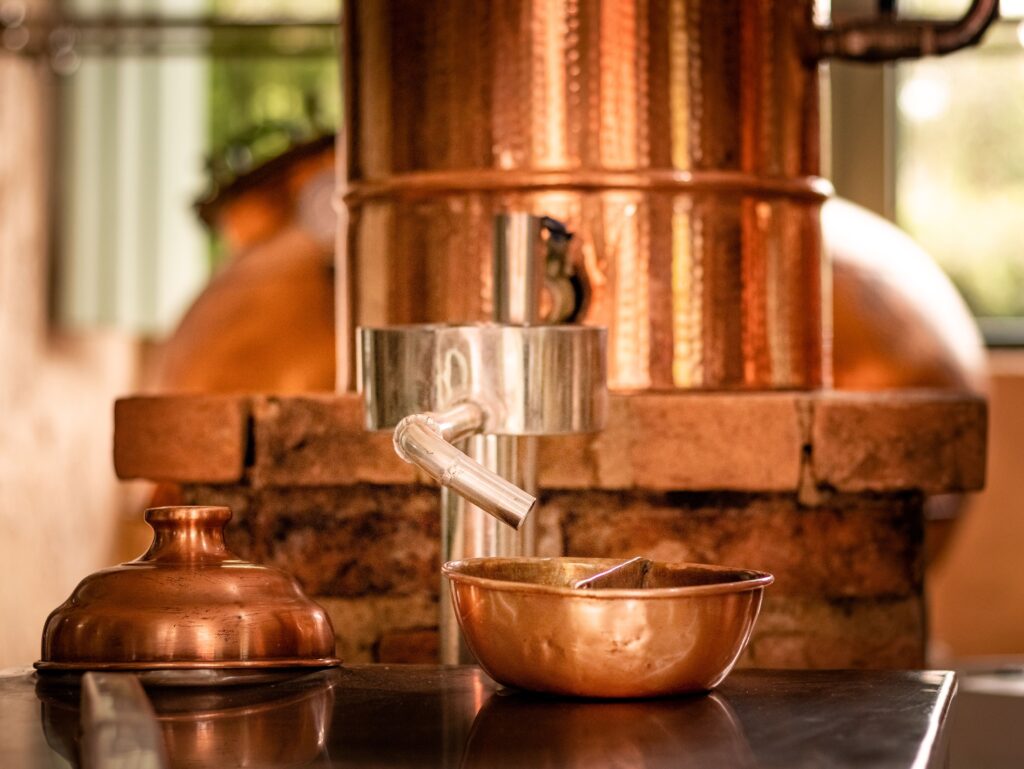 services-04 Close-up of copper distillery apparatus with shiny copper bowls.